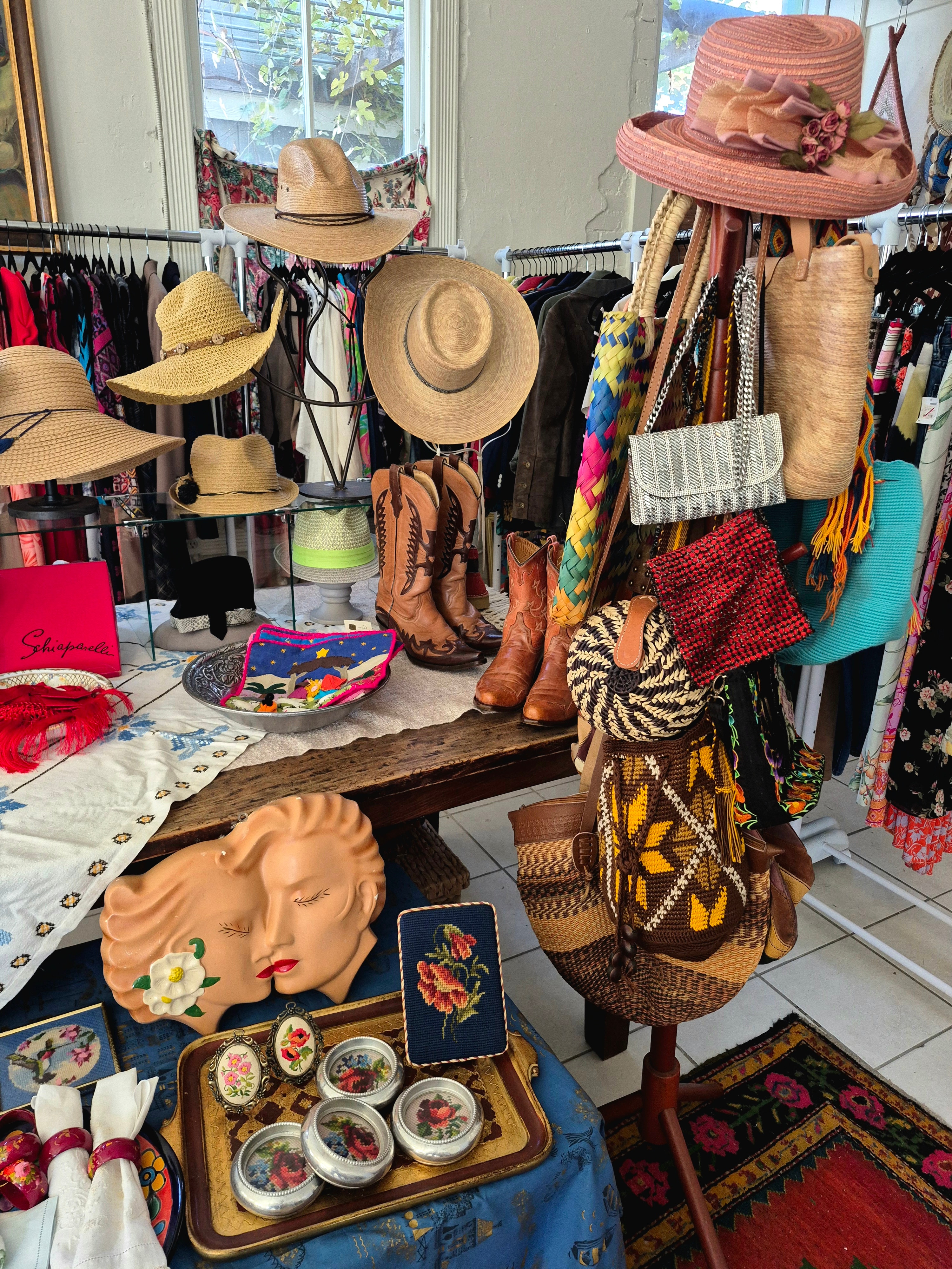 Straw hats, woven bags, ceramic masks and needlepoint purses filling a corner of the shop
