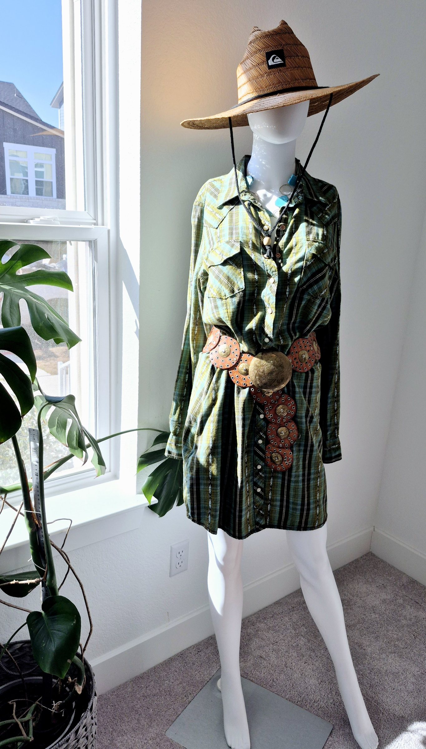 A green vintage outfit mixing plaid, jewelry and a textured belt
